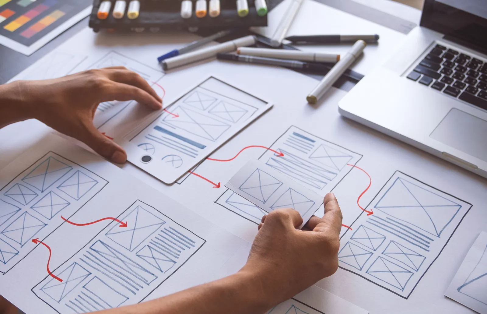 Consultants sketching a product plan across wireframes